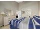 Main bedroom with striped bedding, dresser, and access to a balcony at 1325 Siesta Bayside Dr # 1325B, Sarasota, FL 34242