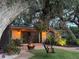 Relaxing patio with fire pit, hanging chair, and lush landscaping at 1827 Baywood Dr, Sarasota, FL 34231
