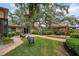 Landscaped backyard with brick pathways, lush greenery, and a pergola at 1827 Baywood Dr, Sarasota, FL 34231