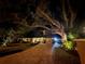 Evening view of home with lit driveway and landscaping at 1827 Baywood Dr, Sarasota, FL 34231