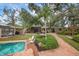 Brick-paved pool area, lush landscaping, and a view of the canal at 1827 Baywood Dr, Sarasota, FL 34231
