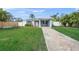 Charming light blue house with brick paver walkway, lush lawn, and fenced yard at 2343 Prospect St, Sarasota, FL 34239