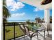 Balcony boasts ocean views, table, chairs, and ceiling fan at 4241 Gulf Of Mexico Dr # 202, Longboat Key, FL 34228