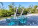 Relaxing patio area with a teal table and chairs near the canal at 563 Juan Anasco Dr, Longboat Key, FL 34228