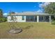 House back view, featuring a screened enclosure and a manicured lawn at 8755 Dolomite Ave, North Port, FL 34287