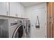 Laundry room with Whirlpool washer and dryer, and built-in cabinets at 8755 Dolomite Ave, North Port, FL 34287