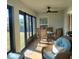 Bright screened porch with wicker furniture, ceiling fan, and view of backyard at 8755 Dolomite Ave, North Port, FL 34287