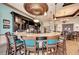 Curved bar with granite countertop and teal barstools at 8912 Heritage Sound Dr, Bradenton, FL 34212