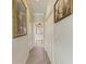 Bright hallway with wood-look tile floors and artwork at 8912 Heritage Sound Dr, Bradenton, FL 34212