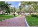 Brick pathway meanders through a lush green community park with mature trees at 111 S Pineapple Ave # 1102, Sarasota, FL 34236