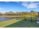 Backyard with a pond view, privacy fence, and lush landscaping at 15808 42Nd E Gln, Parrish, FL 34219
