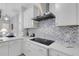 Stylish kitchen with white cabinets, herringbone backsplash and induction cooktop at 15808 42Nd E Gln, Parrish, FL 34219