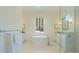 Spa-like bathroom with a freestanding soaking tub, marble floors and walk-in shower at 16511 Cornwall Ln, Bradenton, FL 34202