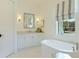 Elegant bathroom with a soaking tub, white cabinets and a large window at 16511 Cornwall Ln, Bradenton, FL 34202