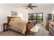 Comfortable bedroom with a wooden sleigh bed, ceiling fan, and access to a balcony at 1704 Pelican Cove Rd # T138, Sarasota, FL 34231