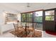 Bright dining area with a glass table and four chairs, overlooking lush greenery at 1704 Pelican Cove Rd # T138, Sarasota, FL 34231
