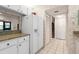 Kitchen with white cabinets, granite counters and view to hallway at 1704 Pelican Cove Rd # T138, Sarasota, FL 34231