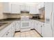 Efficient kitchen offering granite countertops and white appliances at 1704 Pelican Cove Rd # T138, Sarasota, FL 34231