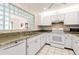 Well-equipped kitchen with granite countertops and white cabinets at 1704 Pelican Cove Rd # T138, Sarasota, FL 34231