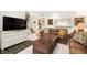 Living area showcasing a brown leather sofa, a large TV, and a white dresser at 1704 Pelican Cove Rd # T138, Sarasota, FL 34231