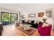 Bright living room with hardwood floors, comfy seating, and sliding glass doors leading to a patio at 1704 Pelican Cove Rd # T138, Sarasota, FL 34231