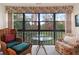 Bright sitting area with comfy chairs, glass-top table, and serene wooded view at 1704 Pelican Cove Rd # T138, Sarasota, FL 34231
