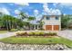 Two-story home with double wooden garage doors and landscaped yard at 1739 Shelburne Ln, Sarasota, FL 34231