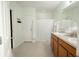 Bright bathroom featuring a double vanity and a shower-tub combo with white shower curtain at 1877 Dragonfly Ave, North Port, FL 34288