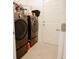 Functional laundry room featuring modern front loading washer and dryer, with tiled floors at 1877 Dragonfly Ave, North Port, FL 34288