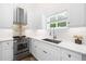 Modern white kitchen with stainless steel appliances and quartz countertops at 2326 Gull Ln, Sarasota, FL 34237