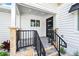 Covered porch with black railing and stone steps leading to the front door at 2326 Gull Ln, Sarasota, FL 34237