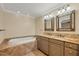 Bathroom with double vanity, granite countertop, and soaking tub at 2961 Homasassa Rd, Sarasota, FL 34239