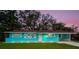 Charming Ranch home with a bright blue exterior, lush lawn, and attractive landscaping at 300 Coral Rd, Venice, FL 34293