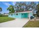 Charming light teal house with a carport and well-maintained lawn at 300 Coral Rd, Venice, FL 34293