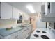 Full view of galley kitchen with white cabinets and teal countertops at 300 Coral Rd, Venice, FL 34293