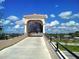 Entrance to The Legacy Trail, a scenic path featuring a covered bridge and lush greenery at 4136 Via Mirada, Sarasota, FL 34238