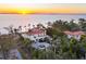 Beautiful estate featuring a circular driveway, mature landscaping and a terracotta roof at sunset at 4311 Bay Shore Rd, Sarasota, FL 34234
