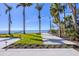 Expansive backyard with lush lawn, palm trees, and waterfront views on a sunny day at 4311 Bay Shore Rd, Sarasota, FL 34234