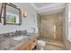 This bathroom features a granite countertop vanity and walk-in shower with tan tile at 4311 Bay Shore Rd, Sarasota, FL 34234