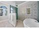 This bath features a unique flower-themed tile, glass shower, and modern soaking tub at 4311 Bay Shore Rd, Sarasota, FL 34234