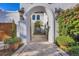 Charming courtyard entrance featuring tiled flooring, potted plants, and an arched doorway leading to the home's interior at 4311 Bay Shore Rd, Sarasota, FL 34234