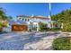 Elegant driveway with a wooden garage door, fountain, and beautiful landscaping leading to the stately home at 4311 Bay Shore Rd, Sarasota, FL 34234