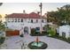 Luxury estate featuring a terracotta roof, circular driveway with fountain, and lush tropical landscaping at 4311 Bay Shore Rd, Sarasota, FL 34234