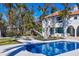 Elegant home exterior with a pool, lush landscaping, and a beautiful waterfront backdrop at 4311 Bay Shore Rd, Sarasota, FL 34234