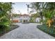 Beautiful estate featuring a circular driveway with a fountain, lush tropical landscaping, and a grand facade at 4311 Bay Shore Rd, Sarasota, FL 34234