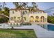 Impressive home exterior with lush landscaping, pool, and scenic waterfront views at dusk at 4311 Bay Shore Rd, Sarasota, FL 34234