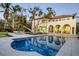 Stunning home exterior featuring a pool, outdoor dining area, and picturesque waterfront views at 4311 Bay Shore Rd, Sarasota, FL 34234
