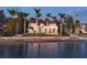 Elegant waterfront home with a red tile roof and lush landscaping, offering serene coastal living at 4311 Bay Shore Rd, Sarasota, FL 34234