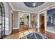 Elegant foyer with hardwood floors, decorative rug, glass table with flower arrangement and views into the living spaces at 4311 Bay Shore Rd, Sarasota, FL 34234