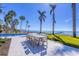 Waterfront patio features a dining area with a modern table and chairs, a pool, and stunning ocean views at 4311 Bay Shore Rd, Sarasota, FL 34234
